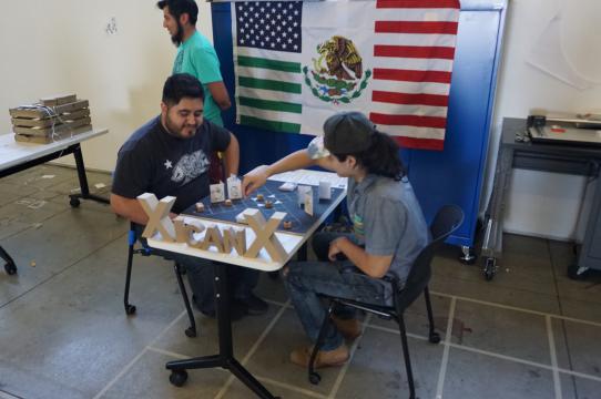 Juan Morales-Rocha playing his game "Xicanx" with a fellow student